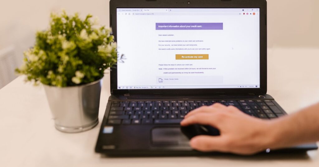 Persona legge un'email sul laptop in ufficio — riconoscere il phishing
